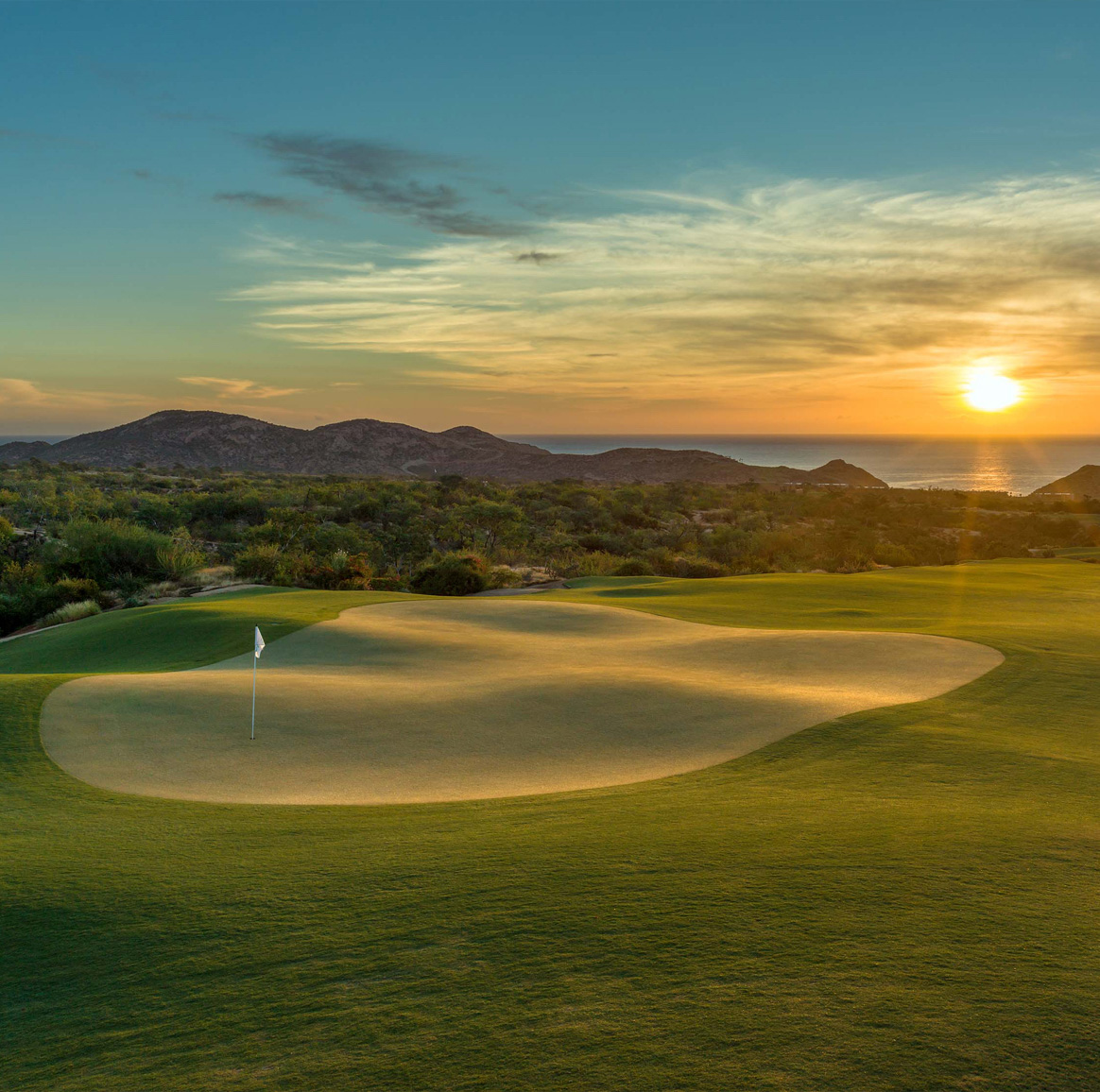 sunset over a putting green at maravilla los cabos golf course
