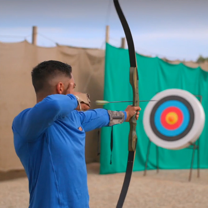 Person with bow and arrow at archery range